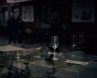 Still Life, Passing Life An empty table, a handful of glasses, and a world moving past the window. Reflections blur the boundary between inside and outside, between stillness and...